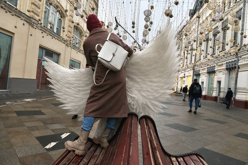 Москва, Россия. Девушка обнимается с актером в костюме ангела на Никольской улице 