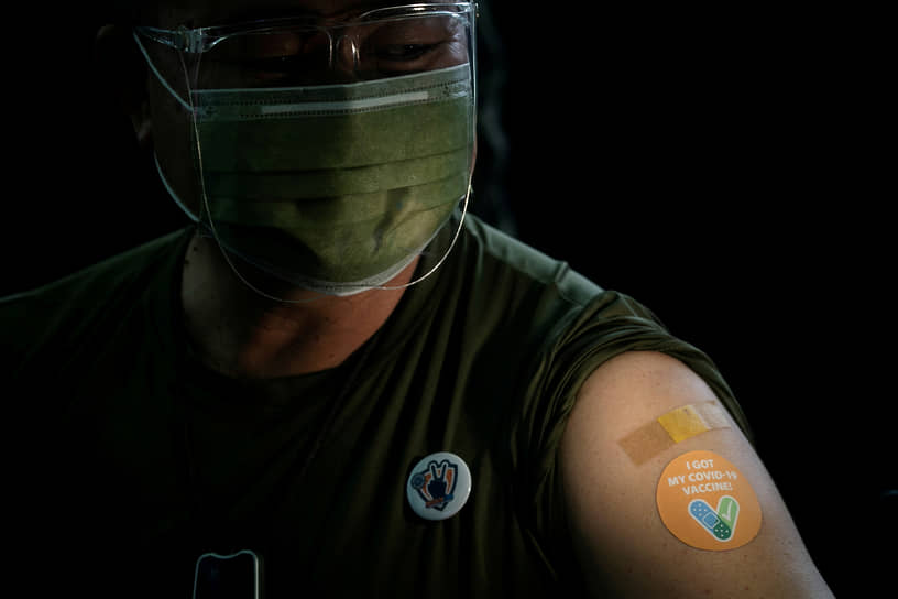 Тагиг, Филиппины. Военный со стикером, который выдают после вакцинации от коронавируса 