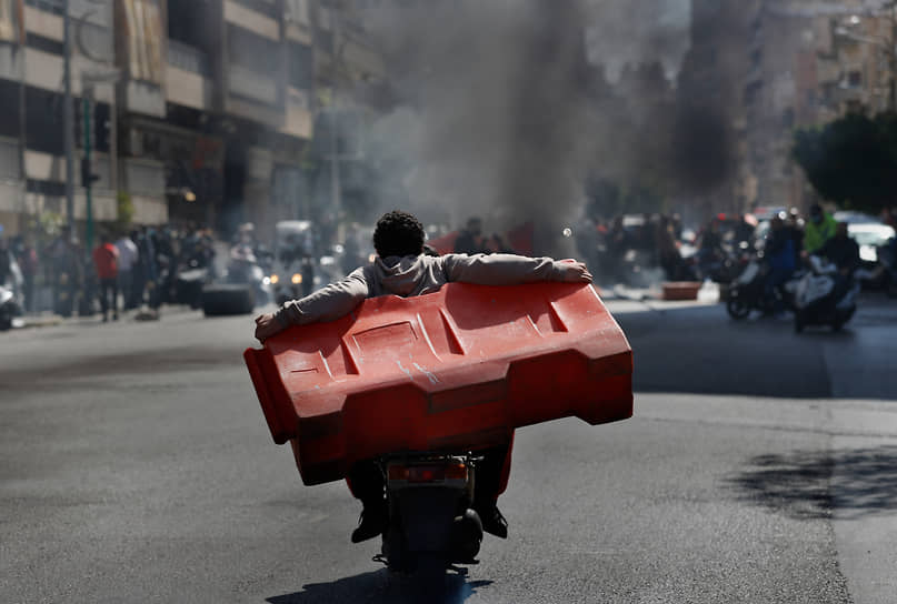 Бейрут, Ливан. Протестующие везут пластиковый дорожный барьер 