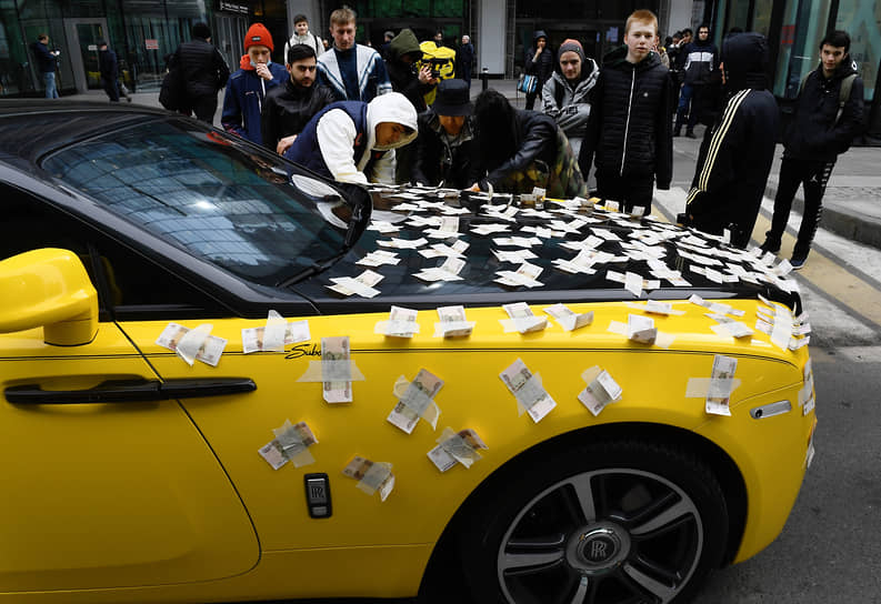 Москва. Блогер Subo обклеивает свою машину денежными купюрами в «Москва-Сити»