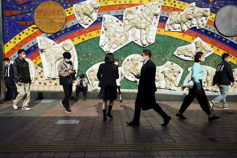 Токио, Япония. Местные жители в защитных масках прогуливаются