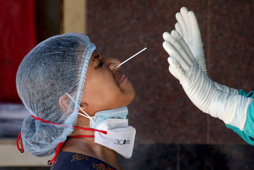 Калькутта, Индия. Медработник пытается взять у женщины мазок на коронавирус 