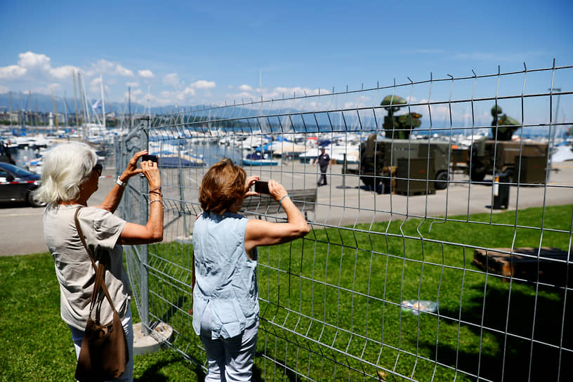 Прохожие фотографируют установленную около виллы Ла-Гранж радиолокационную станцию швейцарской армии