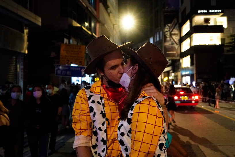 Пара целуется на улице Гонконга во время празднования Хэллоуина