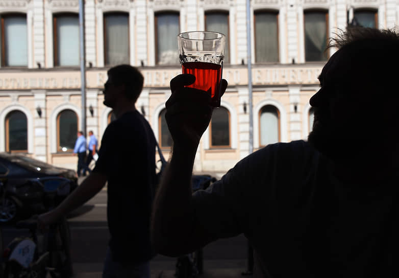 Москва. Мужчина держит в руке стакан с напитком
