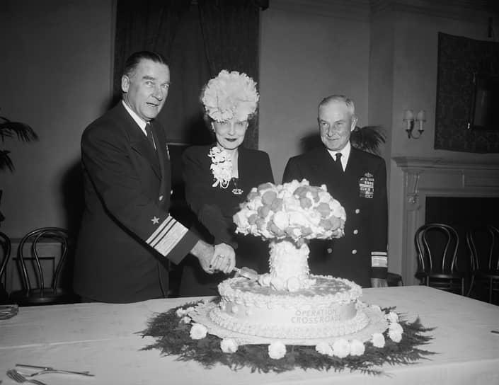 Праздничный торт в форме ядерного гриба в честь операции «Перекресток». Слева направо: вице-адмирал Уильям Бленди, его супруга, конт-адмирал Фрэнк Лоури