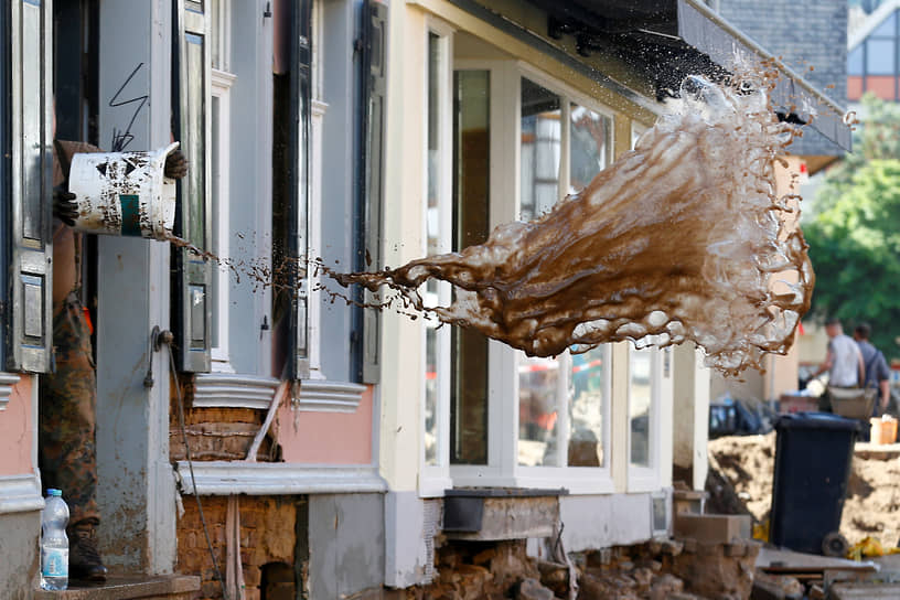 Бад-Мюнстерайфель, Германия. Солдат выливает из дома воду после проливных ливней 
