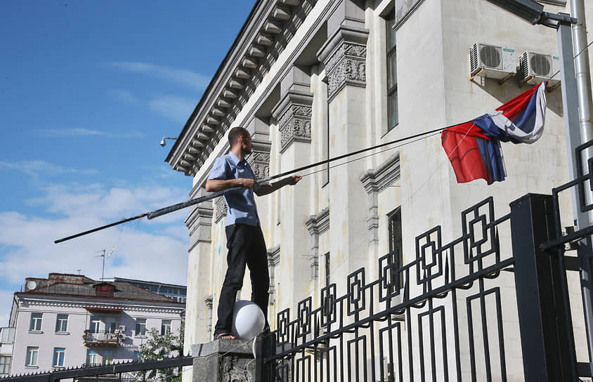Мужчина снимает флаг России со здания посольства России в Киеве. Июнь 2014 года
