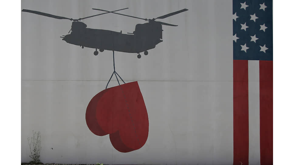 Нарисованный на стене посольства США в Кабуле флаг США и вертолет