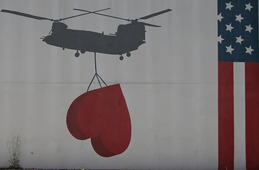 Нарисованный на стене посольства США в Кабуле флаг США и вертолет