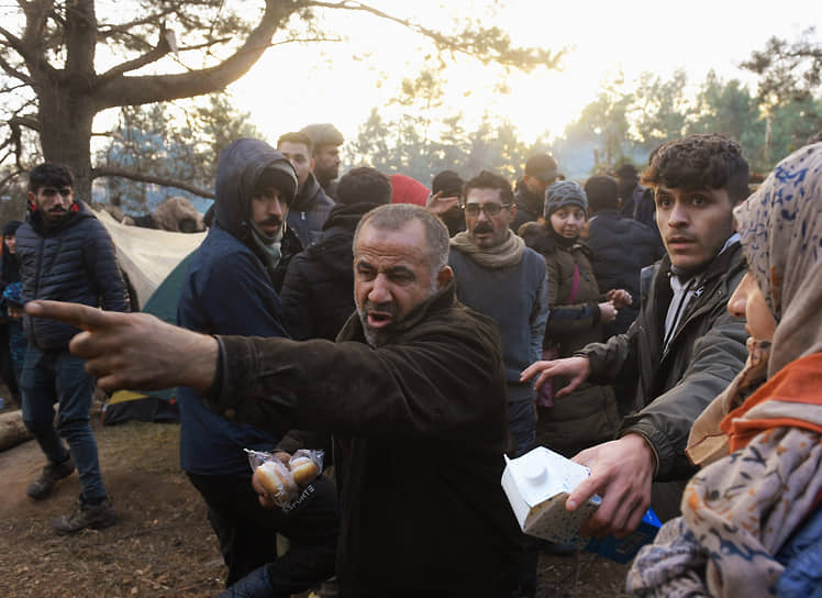Мигранты во время получения гуманитарной помощи с продуктами