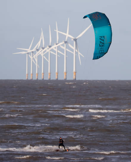 Уолласи, Великобритания. Кайтсерфер катается на фоне ветряной электростанции