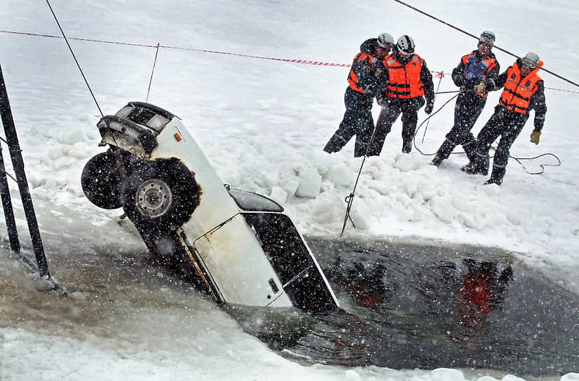 Сотрудники спасательной службы вытаскивают автомобиль из-подо льда во время тренировки в Алтайском крае
