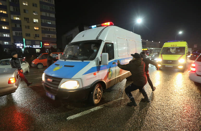 Демонстранты нападают на полицейский микроавтобус во время акции протеста. Алматы