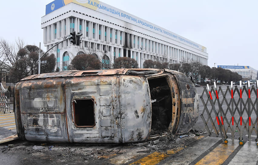 Перевернутый сожженный автобус в районе площади Республики в Алматы