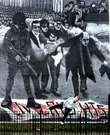 Стенная роспись в районе Богсайд. Отец Эдвард Дейли размахивает окровавленным белым платком, привлекая внимание военных, чтобы те позволили унести смертельно раненого Джеки Дадди
