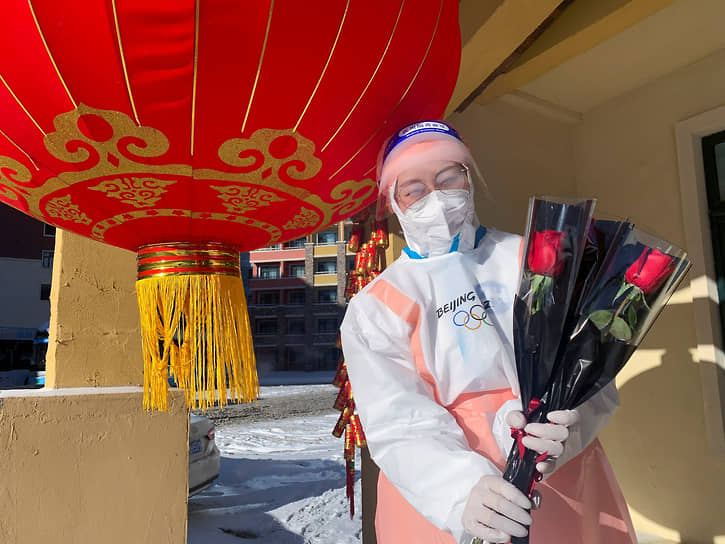Чжанцзякоу, Китай. Волонтер позирует с красными розами