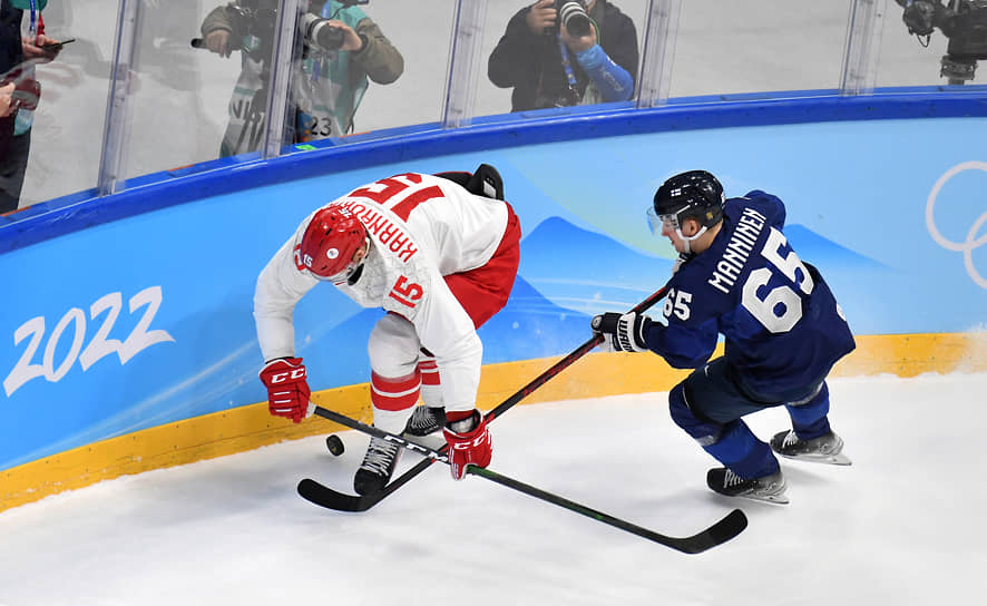 Хоккеисты Павел Карнаухов (слева) и Сакари Маннинен в борьбе за шайбу 