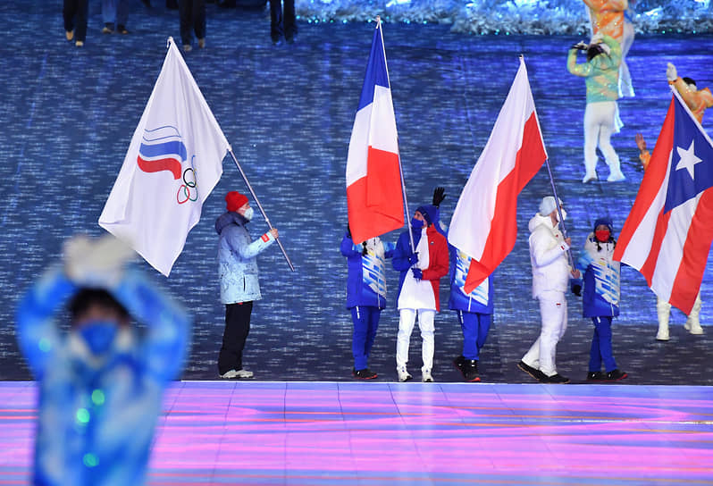 Флаг ОКР, под которым сборная России выступала на Играх в Китае, пронес трехкратный олимпийский чемпион по лыжным гонкам Александр Большунов