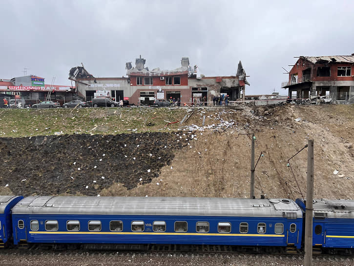 Поезд проезжает мимо района, где спасатели разбирают завалы после обстрела во Львове