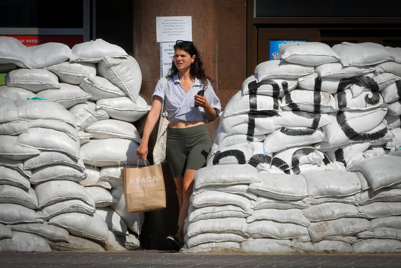 Женщина проходит мимо мешков с песком в центре Киева