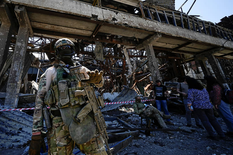 Военнослужащий рядом с разрушенным металлургическим комбинатом «Азовсталь» в Мариуполе