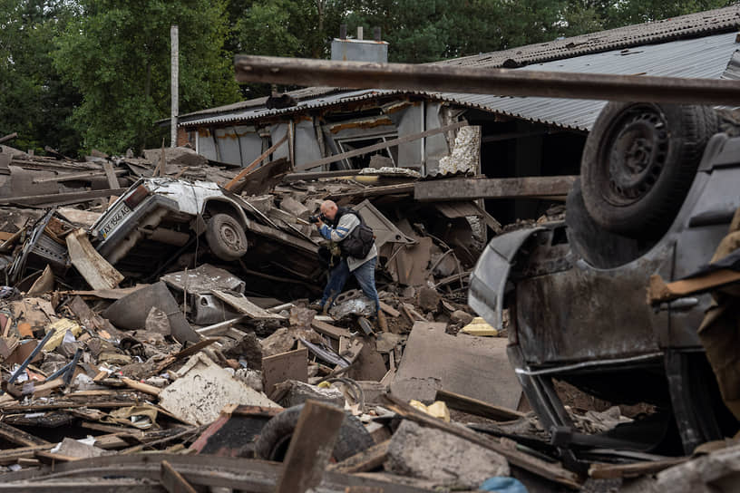 Фотограф за работой у развалин гаражей в Харьковской области 