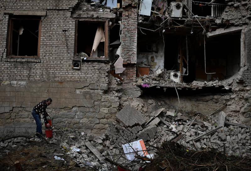 Житель убирает обломки поврежденного дома после обстрела в Константиновке