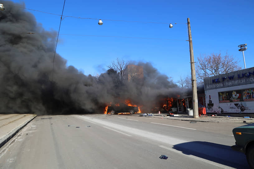 Загоревшийся автомобиль после обстрела в Донецке