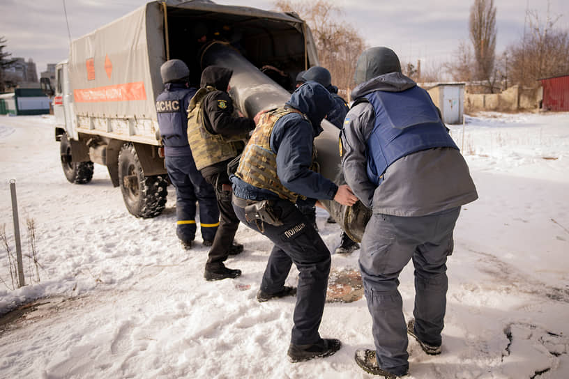 Сотрудники украинских экстренных служб погружают остатки ракеты, упавшей в Харькове, в грузовик