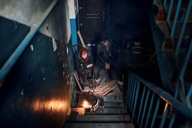 Местные жители готовят еду на лестнице жилого дома в Часовом Яре в Донецкой области