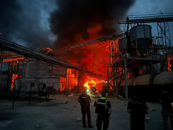Украинские пожарные рядом с горящим заводом после ракетного удара в селе Гоголеве Полтавской области