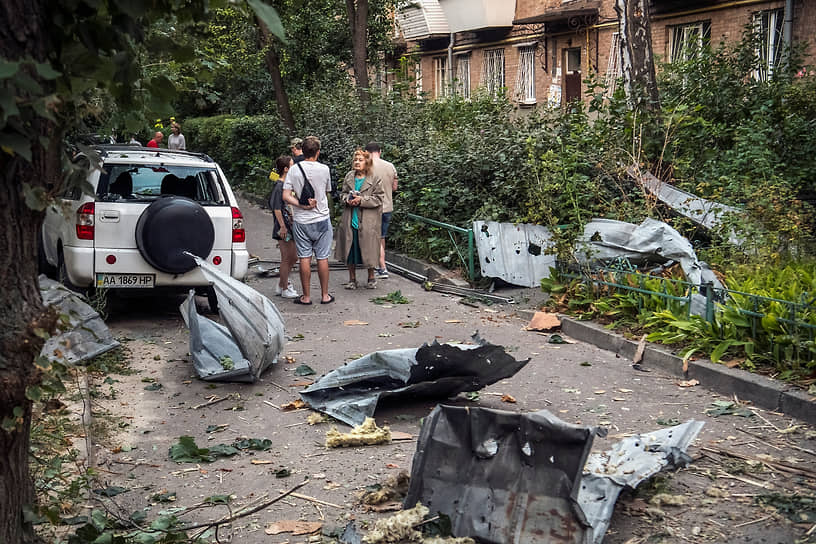 Жители возле поврежденного многоквартирного дома в Киеве