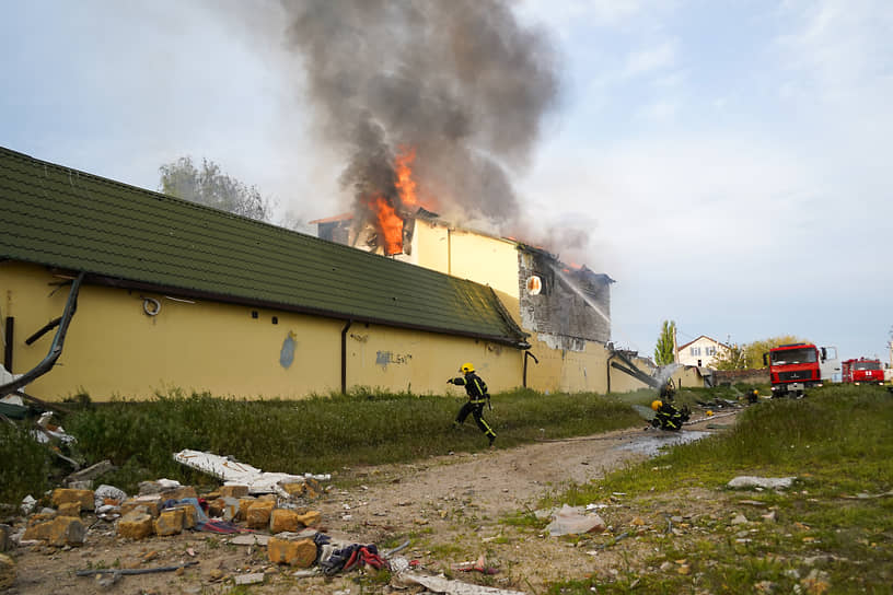 Сотрудники МЧС на месте тушения пожара, возникшего в результате обстрела в Каховке в Херсонской области