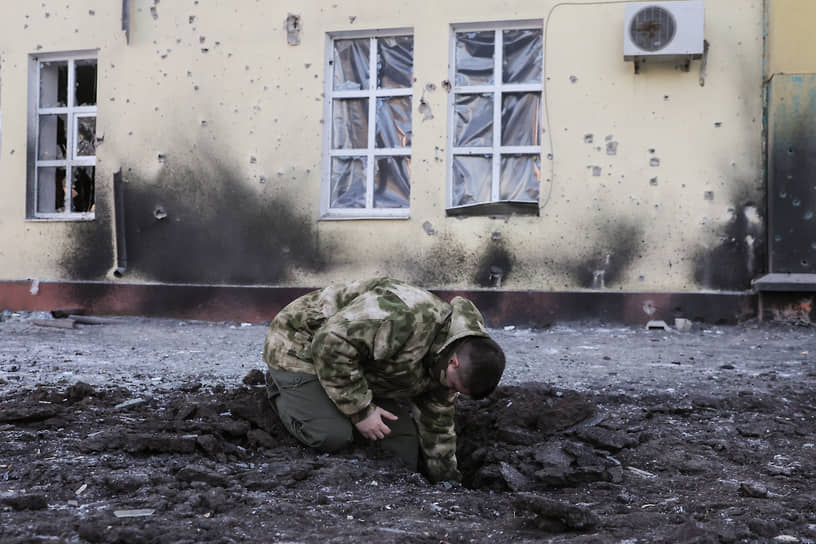 Мужчина у поврежденного дворца культуры в Донецке 