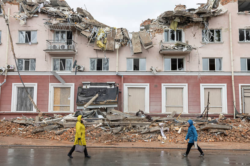 Женщины проходят мимо разрушенной гостиницы «Украина» в Чернигове