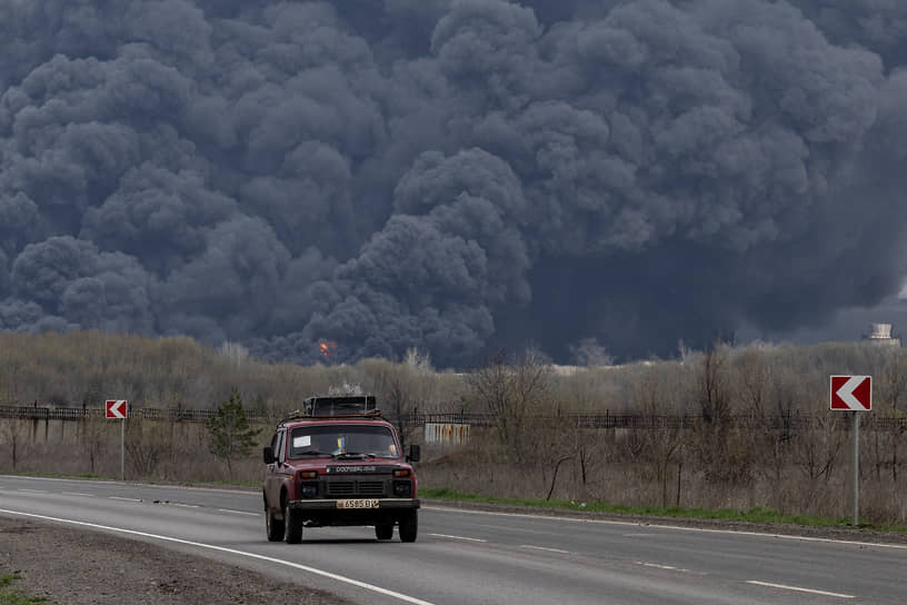 Автомобиль на фоне пожара в Лисичанском нефтеперерабатывающем заводе в Луганской области