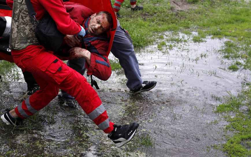 Медработники несут раненого в Харькове