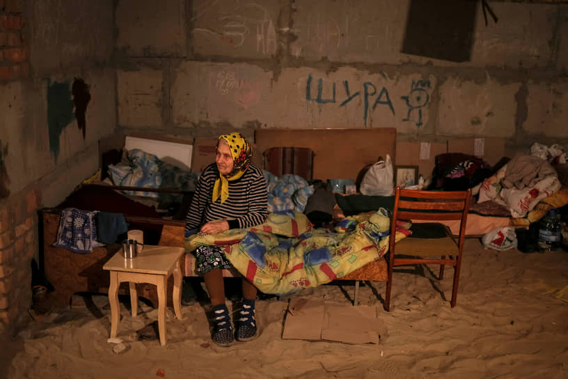 Местная жительница сидит на кровати в бомбоубежище города Соледар