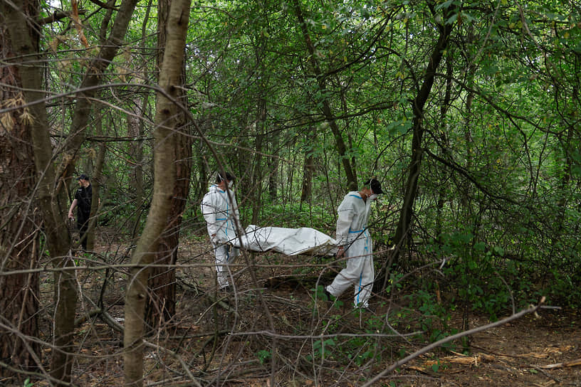 Судмедэксперты несут тело погибшего в селе Ворзель Киевской области