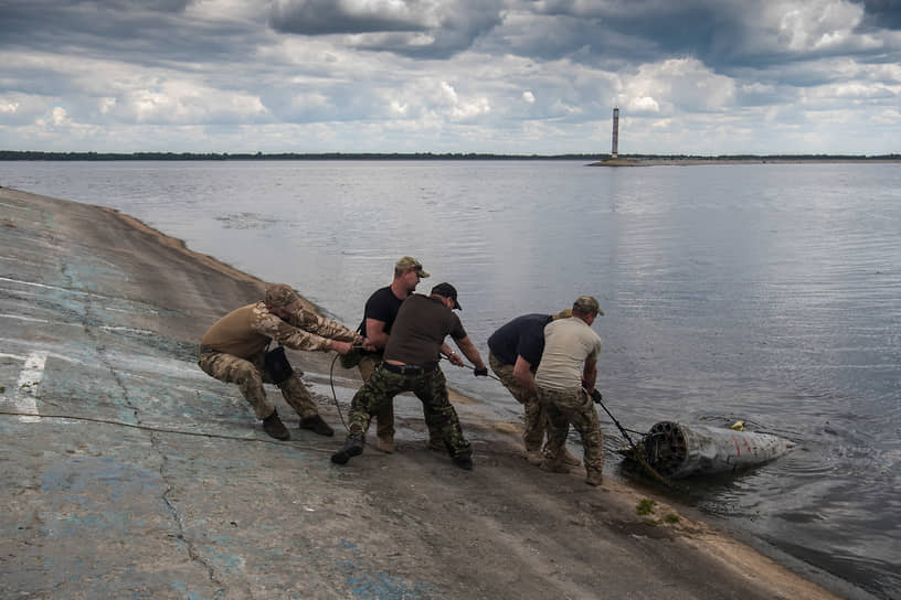 Бойцы национальной гвардии Украины вытаскивают из воды боевой блок с неуправляемыми ракетами с российского военного вертолета Ми-35