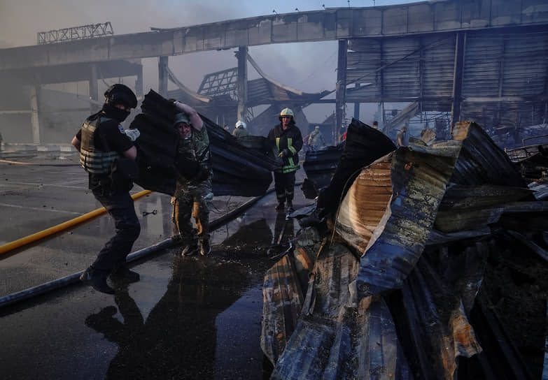Спасатели и военнослужащие разбирают завалы на месте торгового центра в Кременчуге