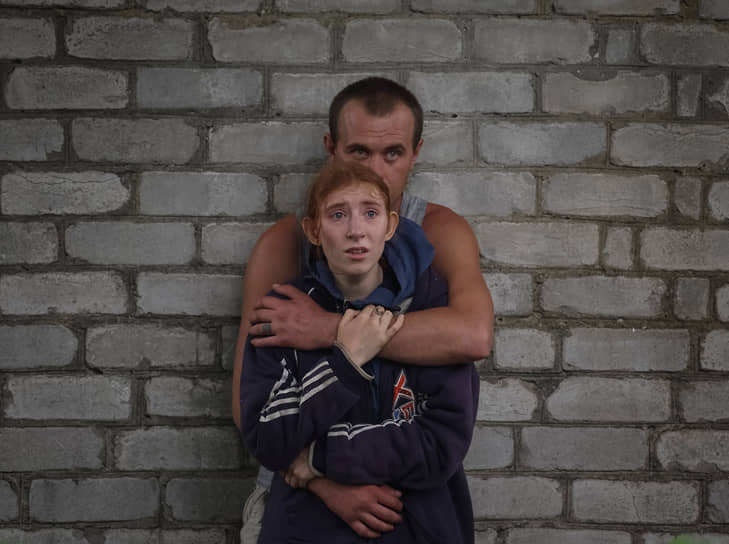 Местные жители наблюдают за работой спасателей в городе Часов Яр Донецкой области