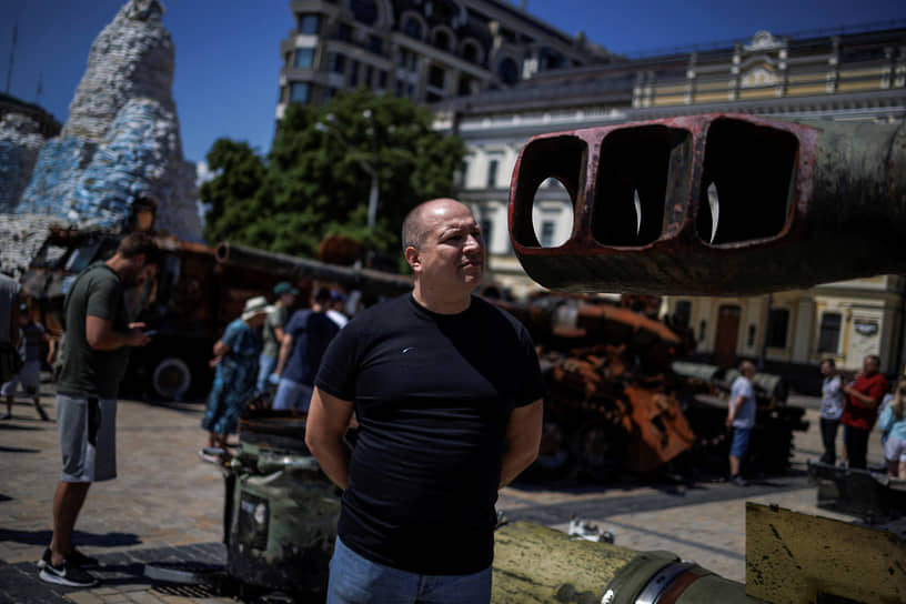 Мужчина смотрит на ствол танка на выставке военной техники в Киеве