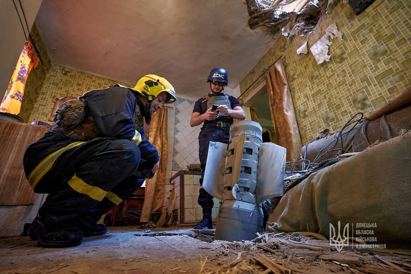 Сотрудники службы экстренной помощи осматривают неразорвавшийся снаряд реактивной системы залпового огня «Смерч» в одной из квартир в Краматорске