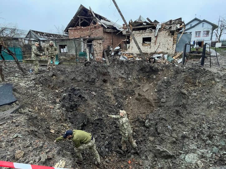 Украинские военнослужащие осматривают воронку в одном из районов Львова