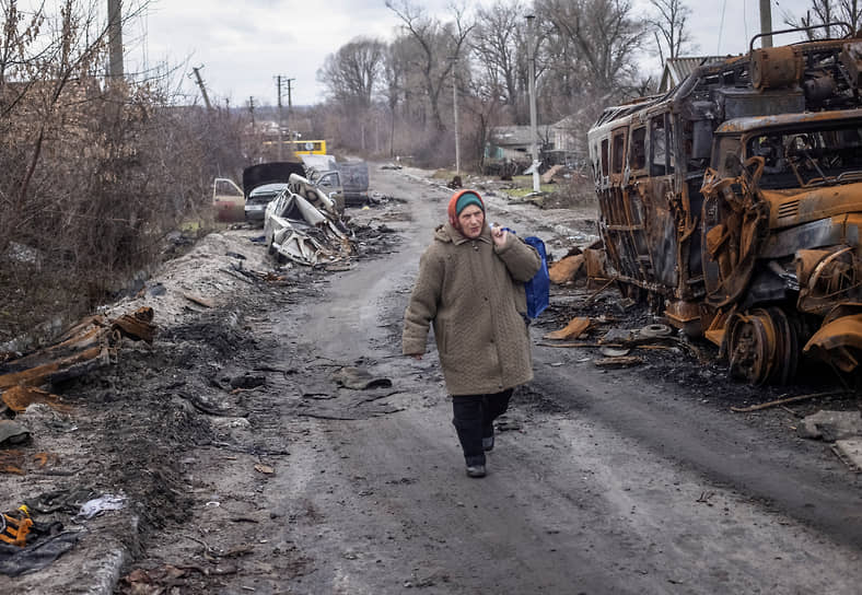 Местная жительница идет по пострадавшей улице в селе Торское