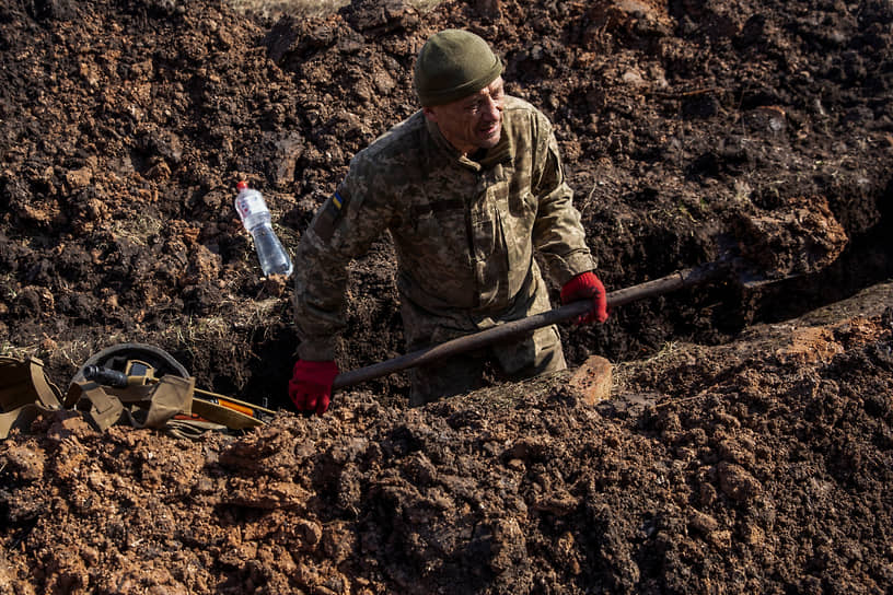 Украинский военнослужащий роет траншею недалеко от города Бахмут в Донецкой области