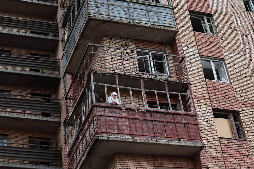Женщина стоит на балконе дома после обстрела в подконтрольной украинским войскам Константиновке