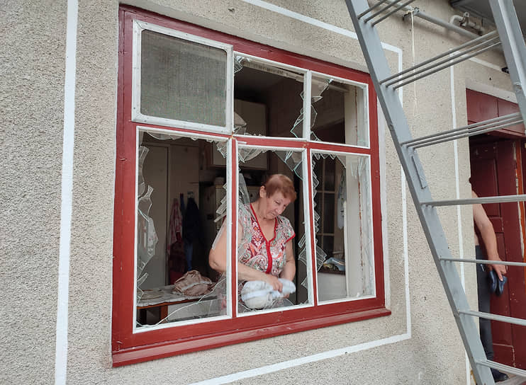 Жительница Николаева убирает осколки разбитого окна